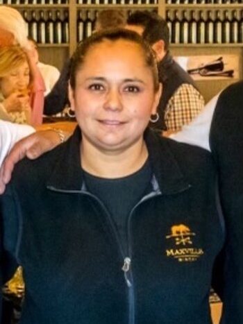 Maxville Winery staff member in uniform at the vineyard, smiling for the camera.