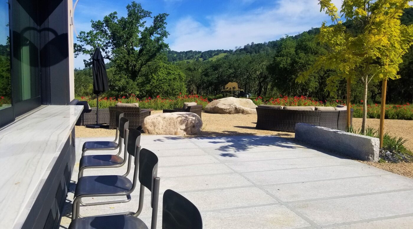 Outdoor seating area at Maxville Winery with chairs, large rocks, and scenic vineyard view.