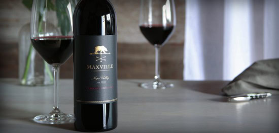 Maxville Winery red wine bottle with two glasses on a dining table.